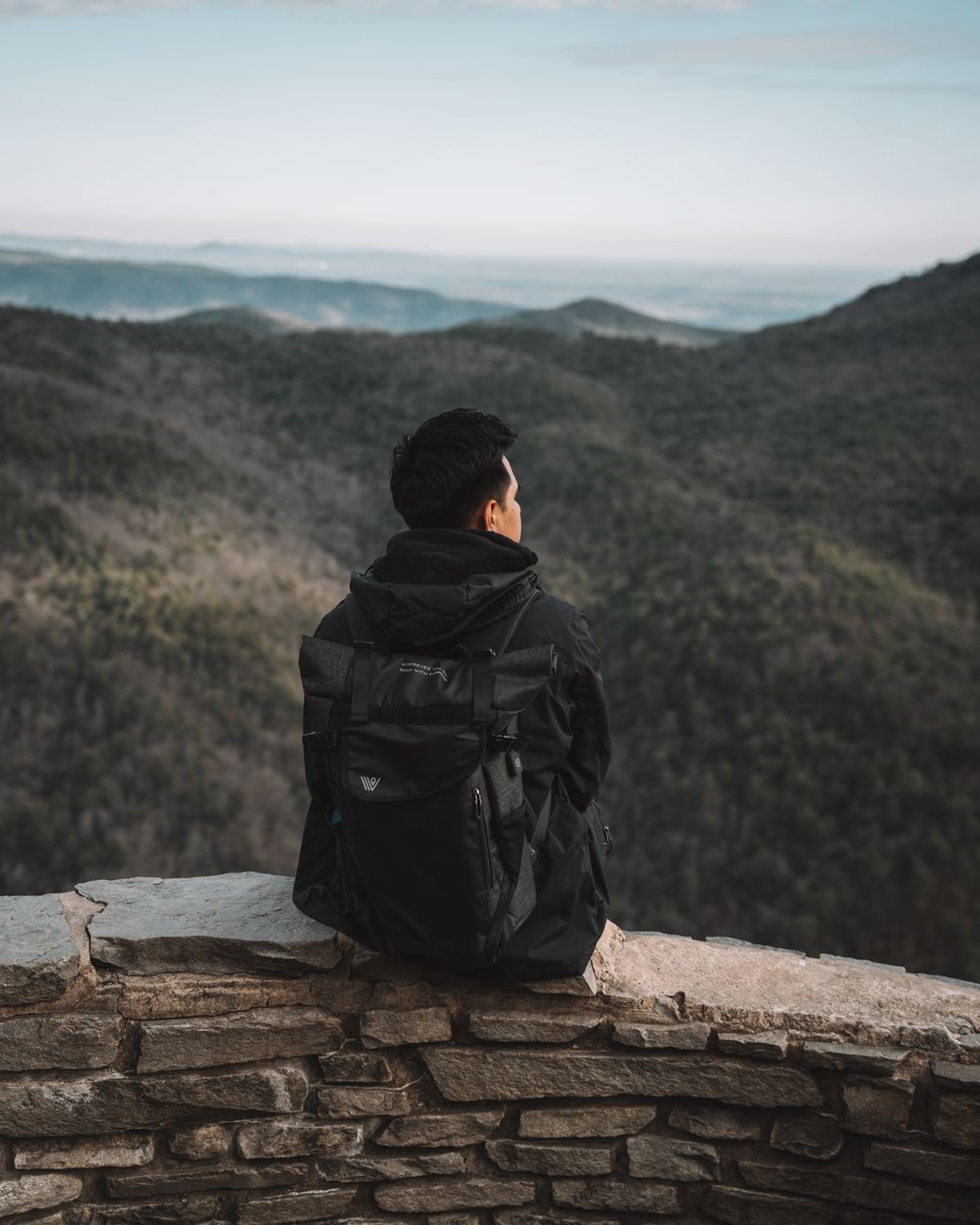 Traveler looking out toward quiet alpine valley
